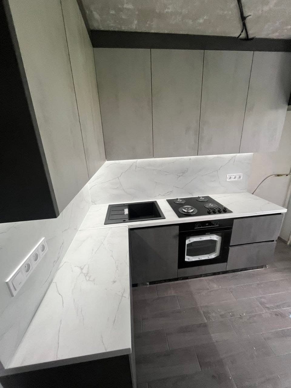 Кутова кухня бетон з білою мармуровою стільницею, газовою панеллю та мийкою